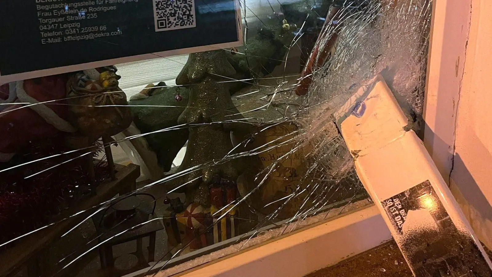 Ein Metallteil des gesprengten Zigarettenautomaten steckt in der Schaufensterscheibe (Foto: Anett Korn)