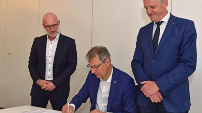 Landrat Kai Emanuel unterzeichnet im Beisein von WGD-Geschäftsführer André Planer (l.) und Oberbürgermeister Manfred Wilde (r.) den Mietvertrag. 				 (Foto: Foto: LRA/Bley)