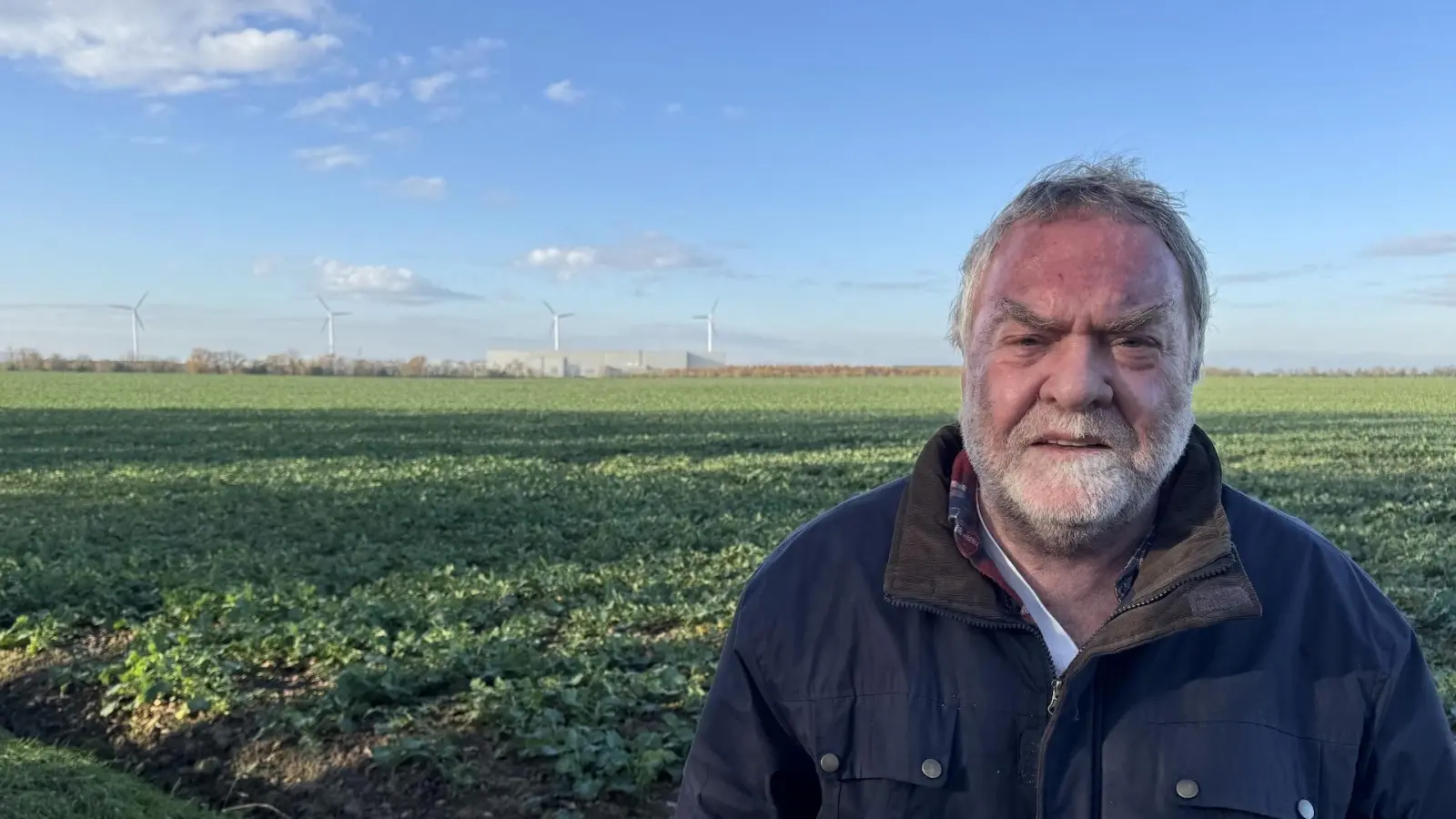 Die Windräder von BMW und das Gewerbegebiet hat Roland Wagner am Rand seines Grundstücks ständig im Blick. Das Feld hinter ihm würde es mit der Erweiterung des Gewerbegebietes nicht mehr geben. (Foto: Daniel Große)